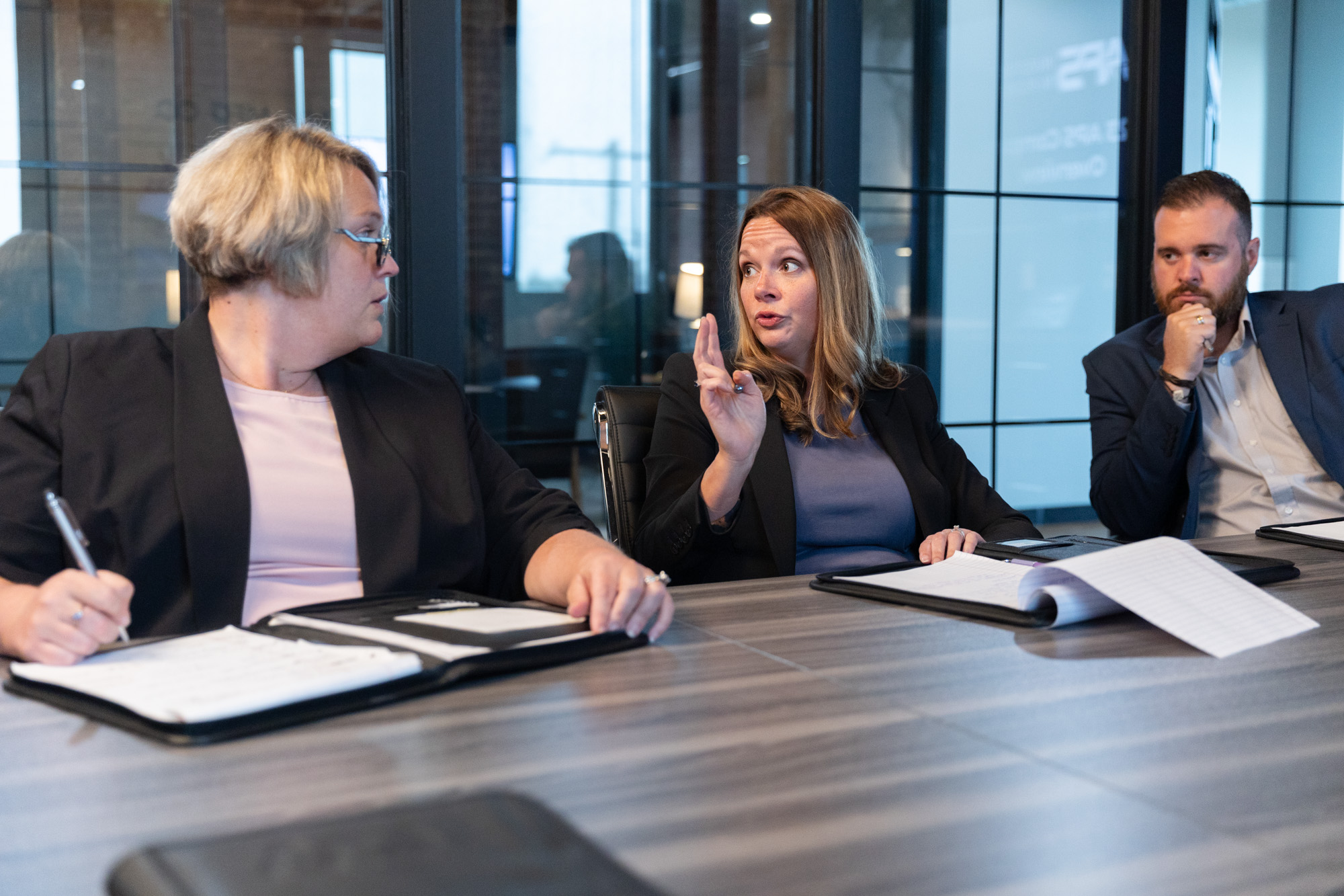 Employees talking at a table discussing data center staffing.